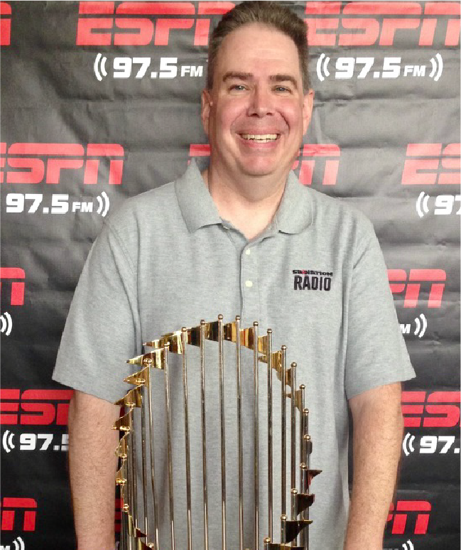 Craig Larson standing behind the World Series championship trophy.