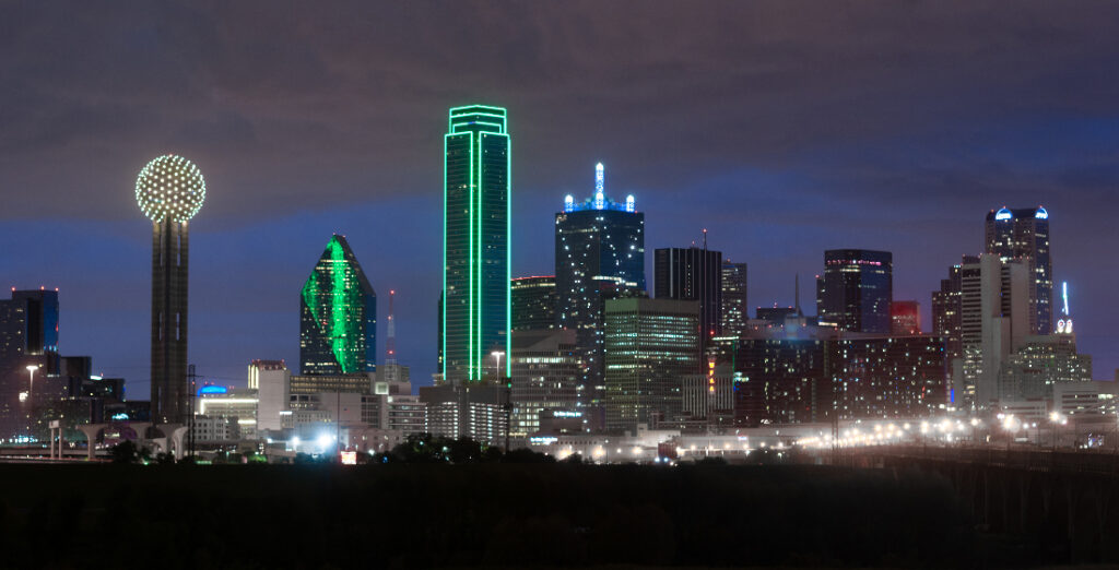 Image of Dallas skyline at night to illustrate how to break into Dallas music scene.