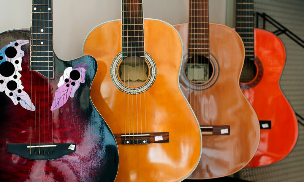 Four guitars of differing colors on display to illustrate is Dallas known for music.