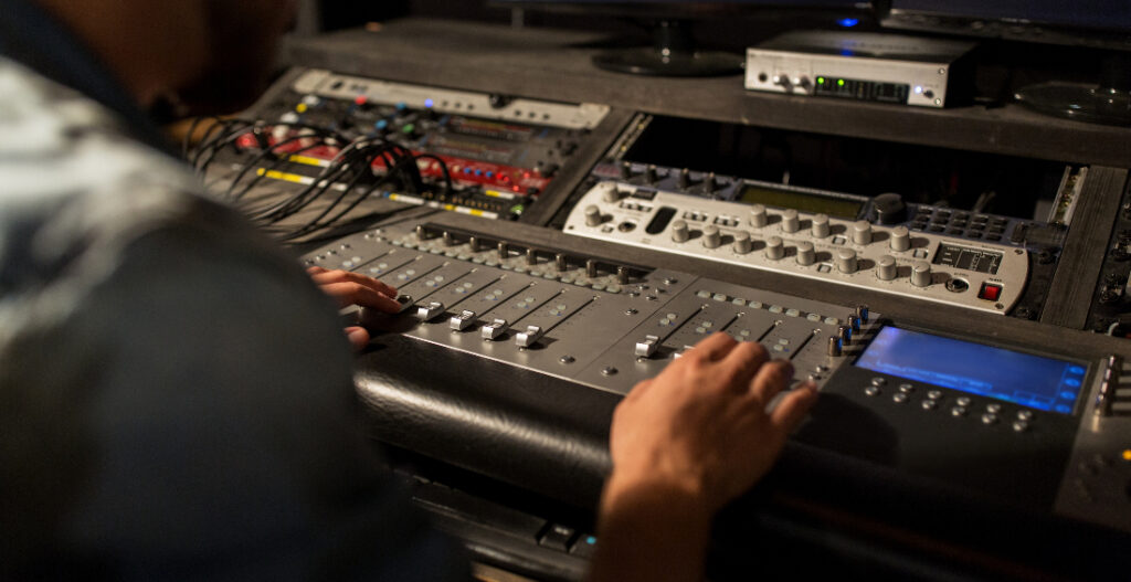 A man using mixing console in sound recording studio